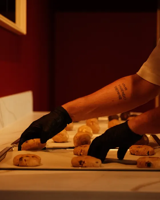 Handen leggen koekdeeg op een bakplaat