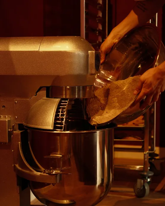 Koekdeeg wordt in de mixer gegoten